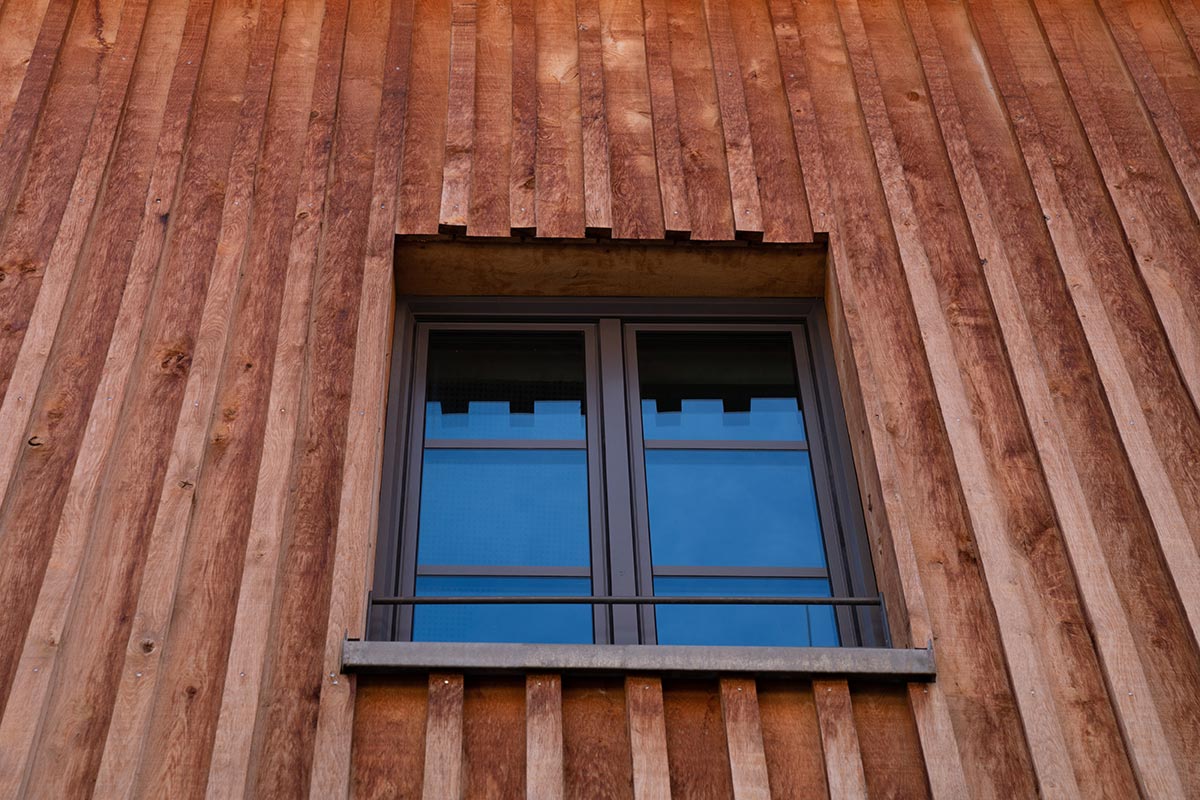 Gebäude mit Holzfassade in Bodendeckelschalung.