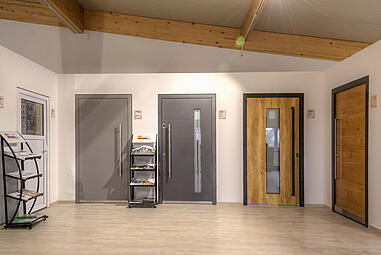 Moderne Türmodelle in der Ausstellung der Schwabenholz GmbH, präsentiert in einem hellen Raum mit Holzbalkendecke.