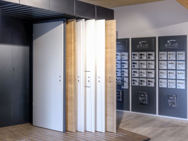 Ausstellung der Schwabenholz GmbH mit modernen weißen und holzfarbenen Türmustern sowie Infowänden zu Produkten.