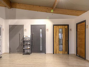 Moderne Türmodelle in der Ausstellung der Schwabenholz GmbH, präsentiert in einem hellen Raum mit Holzbalkendecke.